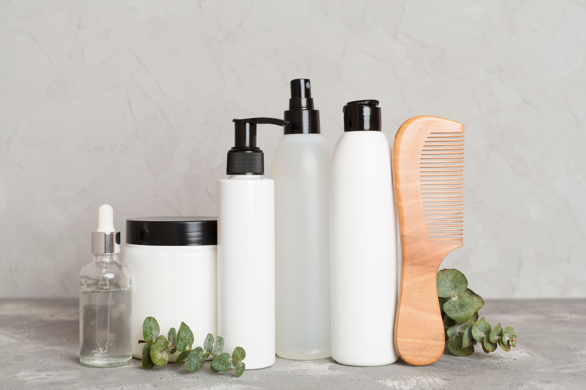 Professional hair care products with comb on table